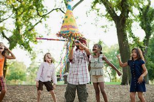 Boy at birthday party hitting pinata